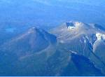 飛行機から雌阿寒岳を見下ろす。火口からは白い煙。左上に見える湖はオンネトー